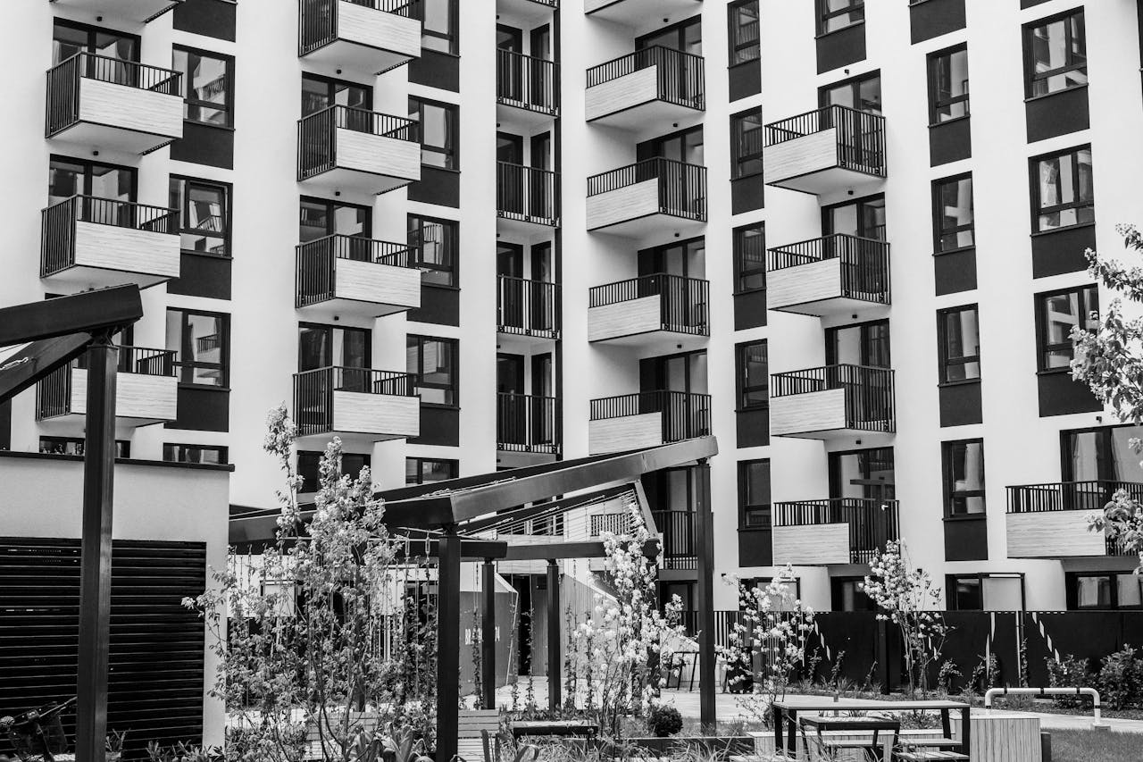 Contemporary urban apartment building with balconies and courtyard, black and white.